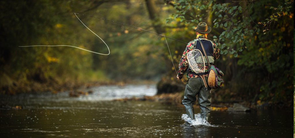 A man casting off while fishing in a river