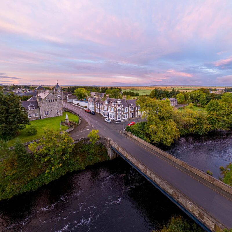 An aerial view of the Ulbster Arms Hotel in Halkirk showing its rural landscape and location at sunset