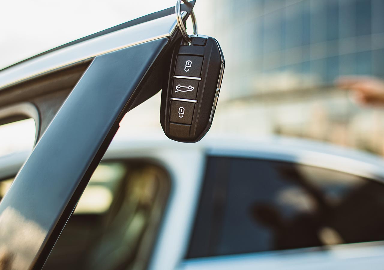 Car keys hang on a car door.