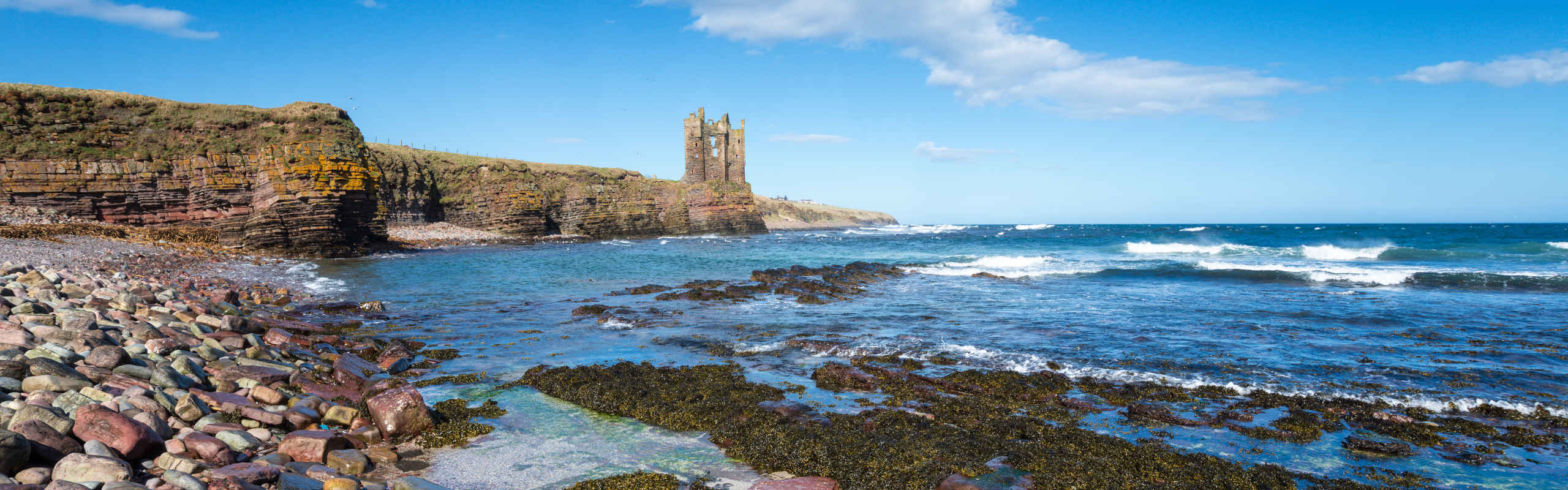 Blue skies over the ruins of Keiss Castle in Caithness