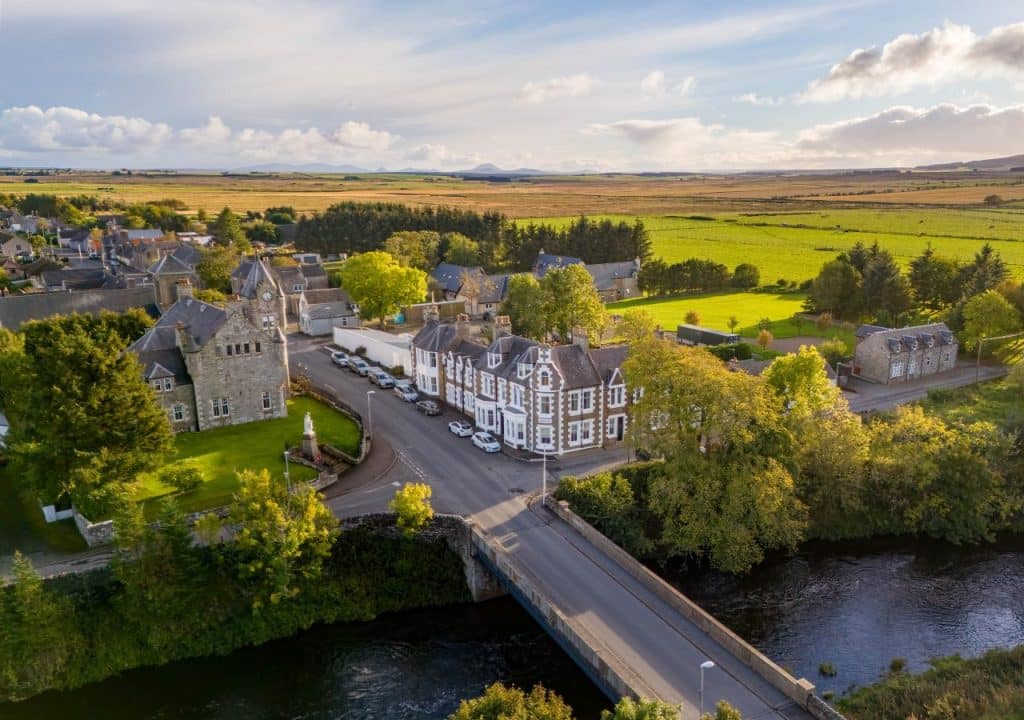 Ulbster Arms Hotel drone shot of the River Thurso and the hotel on its banks.